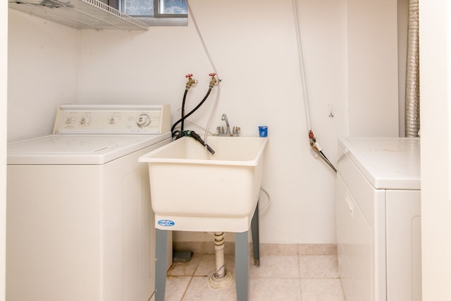 washroom featuring laundry area, independent washer and dryer, light tile patterned floors, and a sink