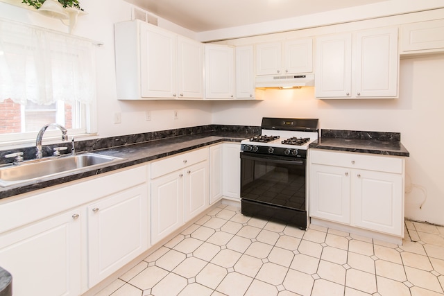 kitchen featuring gas range oven, a sink, white cabinetry, and under cabinet range hood