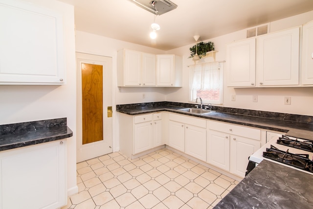 kitchen featuring white cabinetry, visible vents, a sink, and range with gas cooktop
