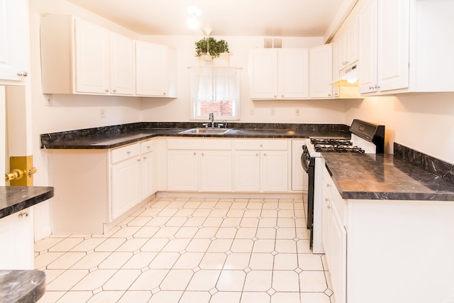 kitchen with under cabinet range hood, a sink, dark countertops, visible vents, and black gas stove