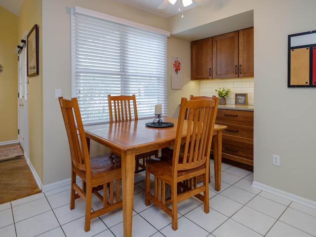 dining room with light tile patterned floors, baseboards, and ceiling fan