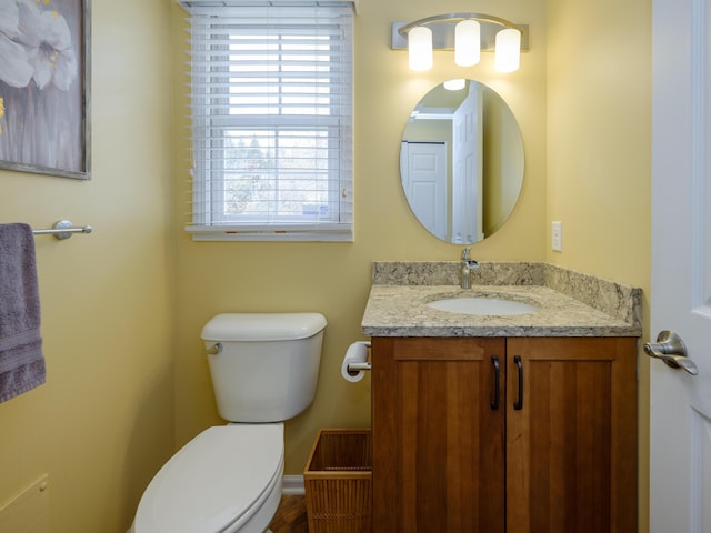 bathroom with toilet, baseboards, and vanity