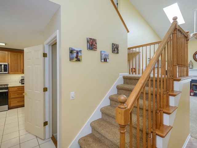 stairway with a skylight and tile patterned floors