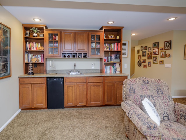 bar with a sink, light colored carpet, indoor wet bar, and black dishwasher