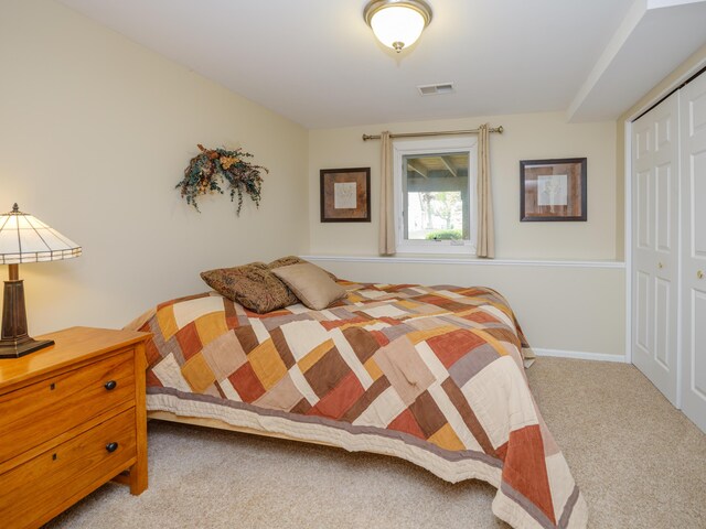 carpeted bedroom featuring a closet and visible vents