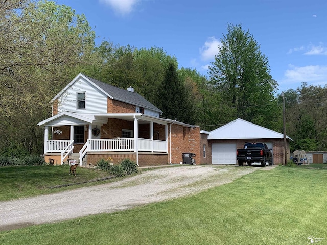 view of front of home featuring an outbuilding, a porch, brick siding, and a front yard