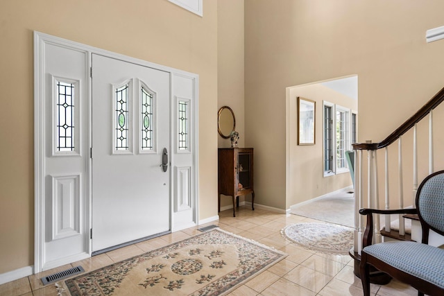 3603 Creekside Dr, Ann Arbor, MI 48105 - foyer with light tile patterned floors, a high ceiling, visible vents, baseboards, and stairs