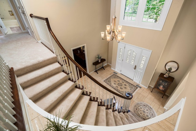 3603 Creekside Dr, Ann Arbor, MI 48105 - foyer entrance featuring an inviting chandelier, a high ceiling, stairway, tile patterned flooring, and baseboards
