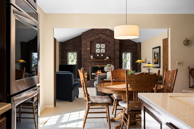 3603 Creekside Dr, Ann Arbor, MI 48105 - dining room with light tile patterned floors, a wealth of natural light, a fireplace, and vaulted ceiling