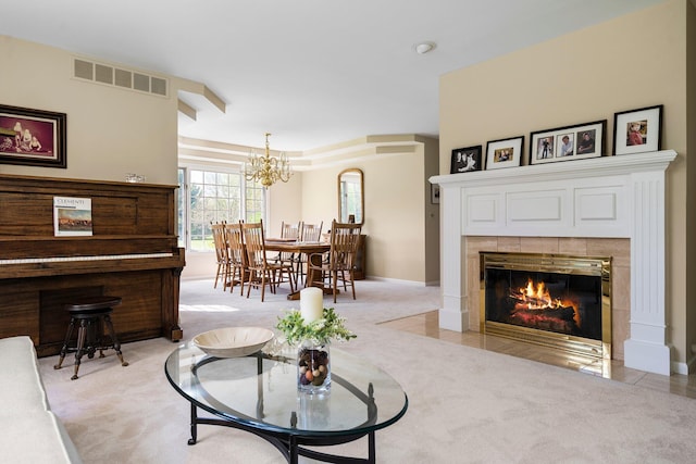 3603 Creekside Dr, Ann Arbor, MI 48105 - living room featuring a notable chandelier, baseboards, a tiled fireplace, visible vents, and light carpet
