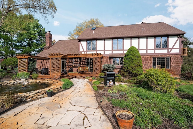 3603 Creekside Dr, Ann Arbor, MI 48105 - rear view of property featuring a chimney, a patio, a pergola, a shingled roof, and a wooden deck