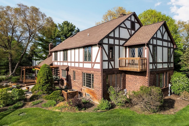 3603 Creekside Dr, Ann Arbor, MI 48105 - rear view of house with brick siding, a yard, a chimney, a sunroom, and a shingled roof