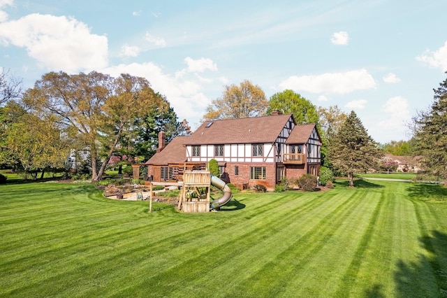 3603 Creekside Dr, Ann Arbor, MI 48105 - rear view of property with a shingled roof, brick siding, a yard, a chimney, and a playground