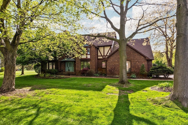 3603 Creekside Dr, Ann Arbor, MI 48105 - tudor home featuring a front lawn, brick siding, and roof with shingles