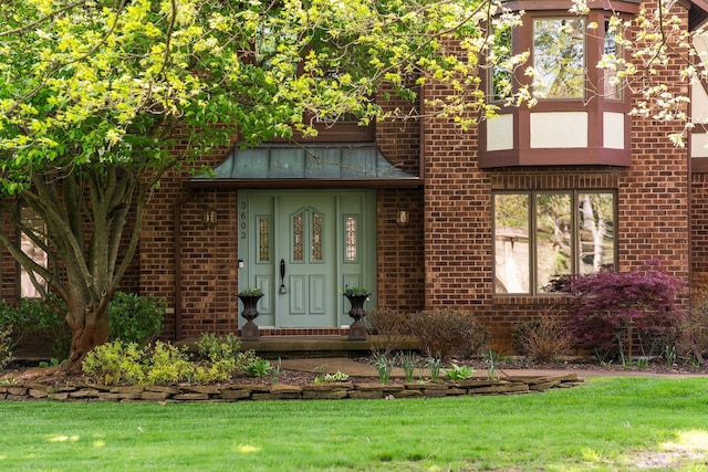 3603 Creekside Dr, Ann Arbor, MI 48105 - view of exterior entry featuring a yard and brick siding