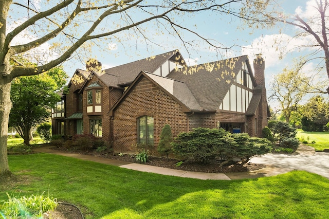 3603 Creekside Dr, Ann Arbor, MI 48105 - view of side of home featuring a shingled roof, brick siding, a chimney, and a lawn