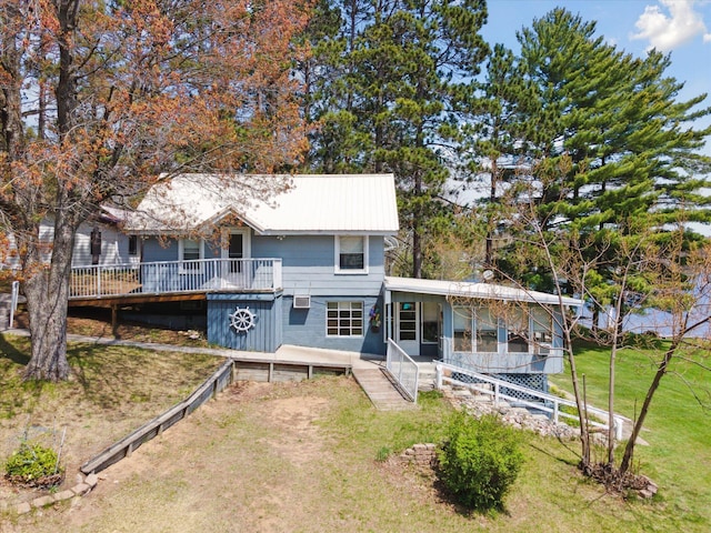 10458 Sleepy Hollow Ln, Mecosta, MI 49332 - view of front of property with a front lawn, a wooden deck, a sunroom, and metal roof