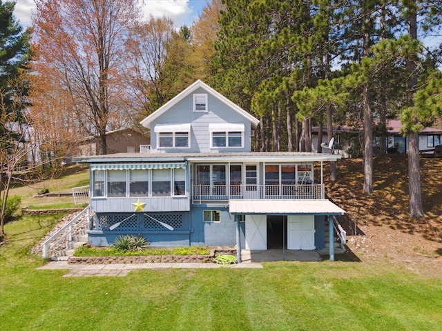 10458 Sleepy Hollow Ln, Mecosta, MI 49332 - rear view of property featuring a sunroom, stairway, a lawn, and metal roof