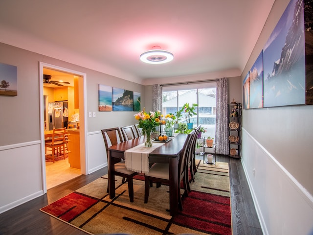 dining room featuring dark wood-style flooring, baseboards, and ceiling fan