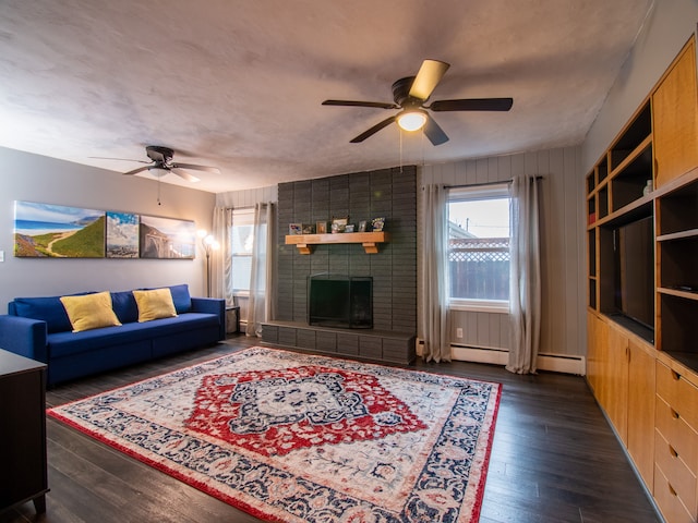 living room featuring ceiling fan, wood finished floors, and a fireplace
