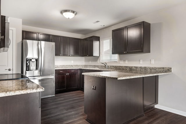kitchen with a peninsula, stainless steel fridge with ice dispenser, dark wood-type flooring, and dark brown cabinets