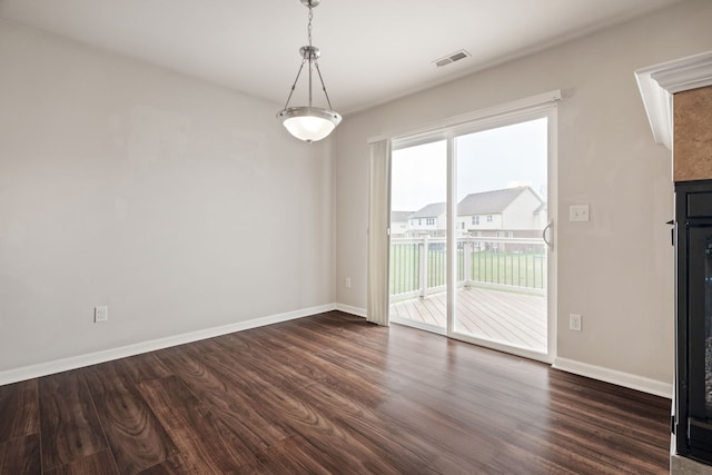spare room featuring baseboards, dark wood-type flooring, and visible vents