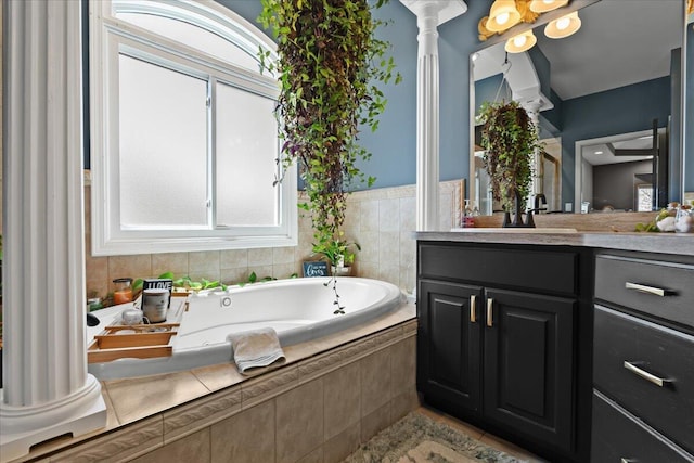 full bathroom featuring a bath, tile patterned flooring, vanity, and ornate columns
