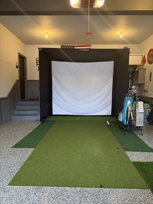 recreation room featuring a wainscoted wall, a putting area, and golf simulator