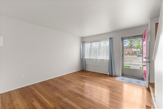 empty room with light wood-type flooring and baseboards