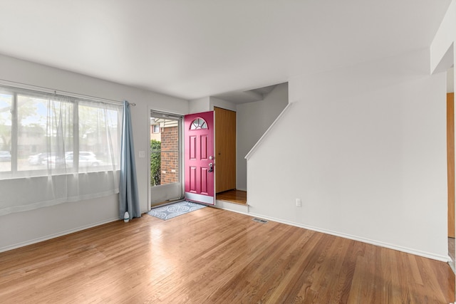 foyer entrance with wood finished floors and baseboards
