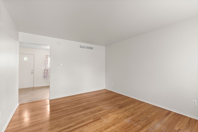empty room featuring light wood finished floors and baseboards