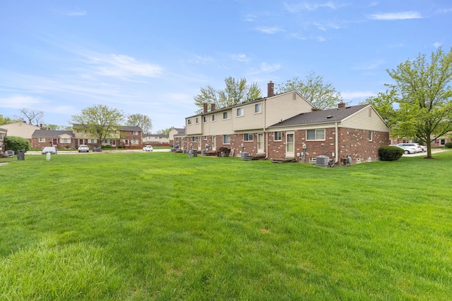 view of green lawn featuring central AC
