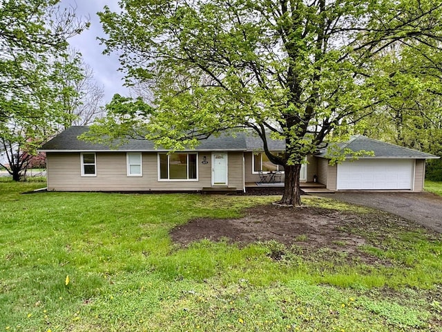ranch-style house featuring aphalt driveway, an attached garage, and a front yard