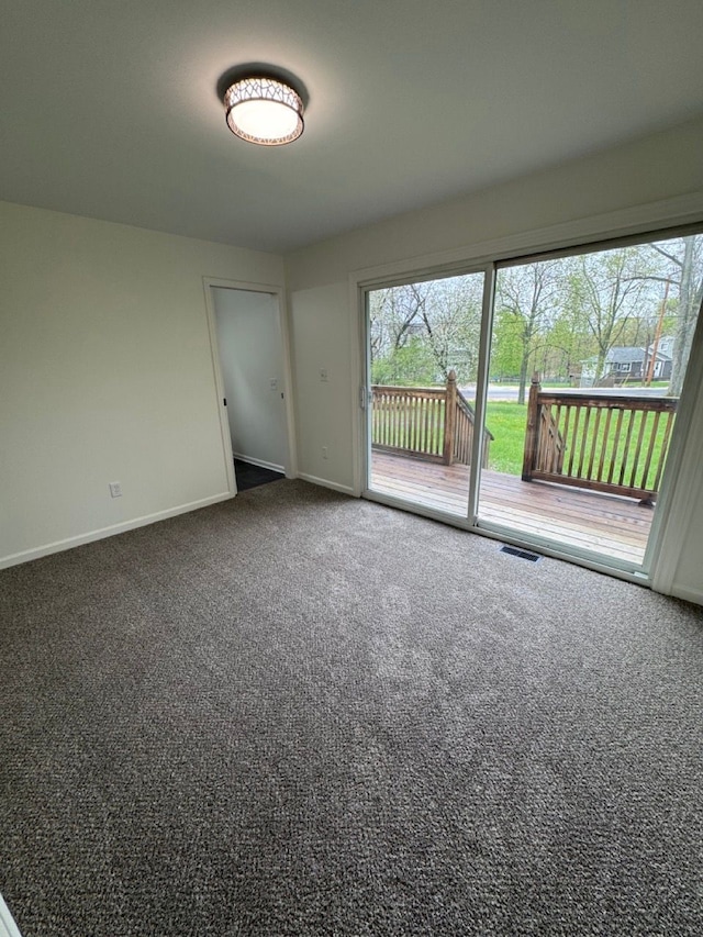 carpeted empty room featuring visible vents and baseboards