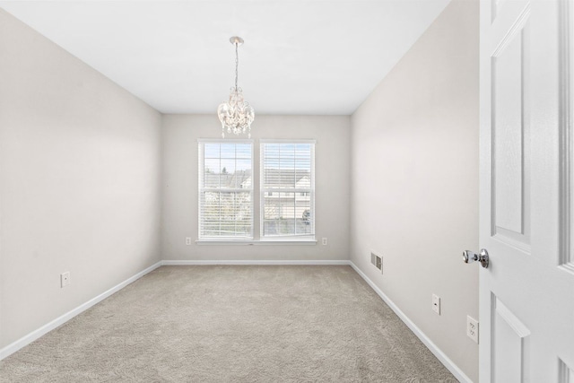 empty room featuring carpet flooring, visible vents, baseboards, and a notable chandelier