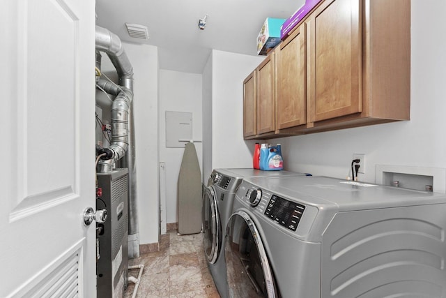 laundry room with cabinet space, stone finish floor, visible vents, washing machine and clothes dryer, and baseboards