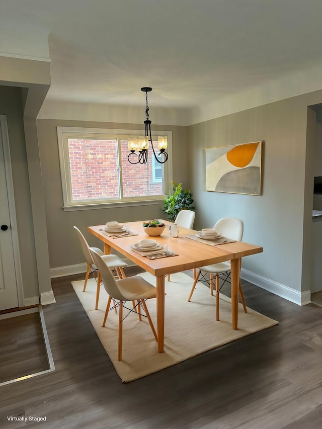 dining area featuring baseboards, dark wood-style floors, and a notable chandelier