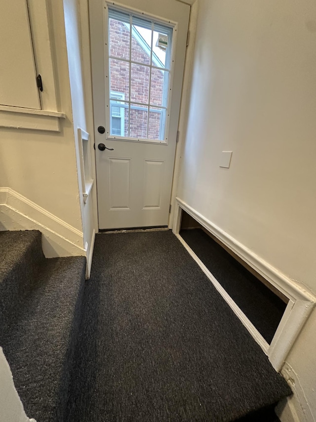 doorway to outside with baseboards, stairs, and carpet