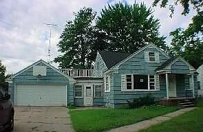 view of front of home with an attached garage, a front lawn, and driveway