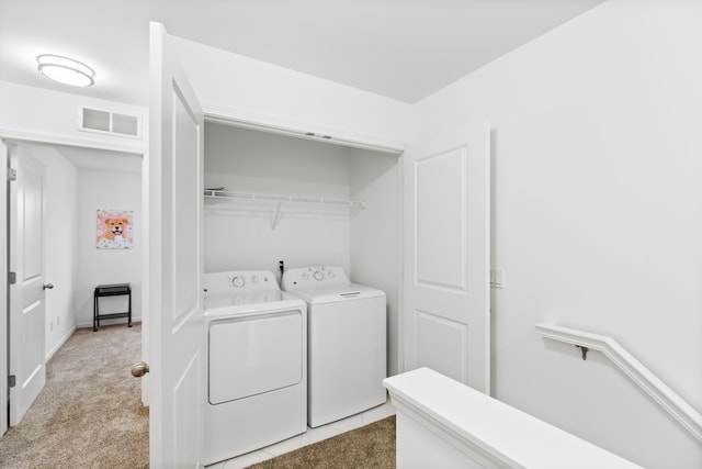 laundry room featuring separate washer and dryer and light colored carpet