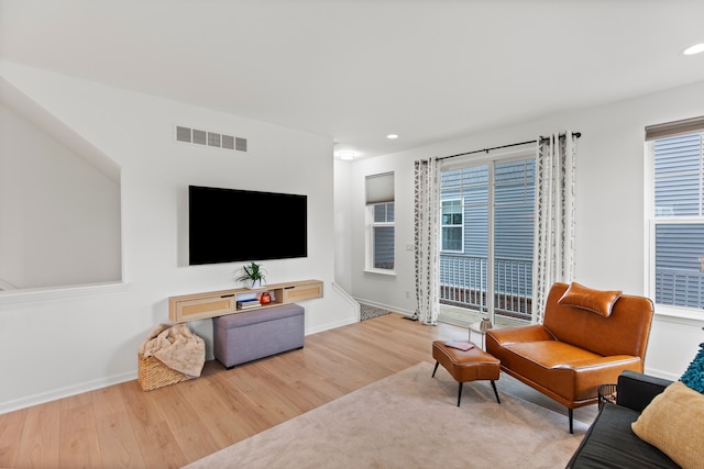 living area with wood finished floors, recessed lighting, plenty of natural light, and baseboards