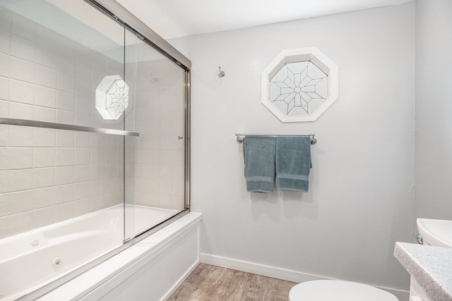 3012 Lansdowne Rd, Waterford, MI 48329 - bathroom with wood finished floors, toilet, bath / shower combo with glass door, and vanity