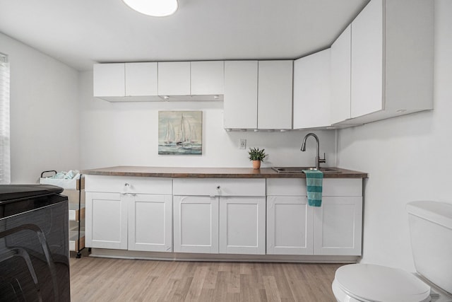 3012 Lansdowne Rd, Waterford, MI 48329 - kitchen with a sink, light wood-type flooring, white cabinets, and dark countertops