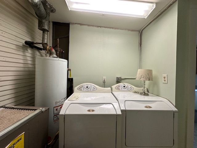 19916 Salem St, Detroit, MI 48219 - laundry room featuring washer and clothes dryer, gas water heater, wooden walls, and laundry area