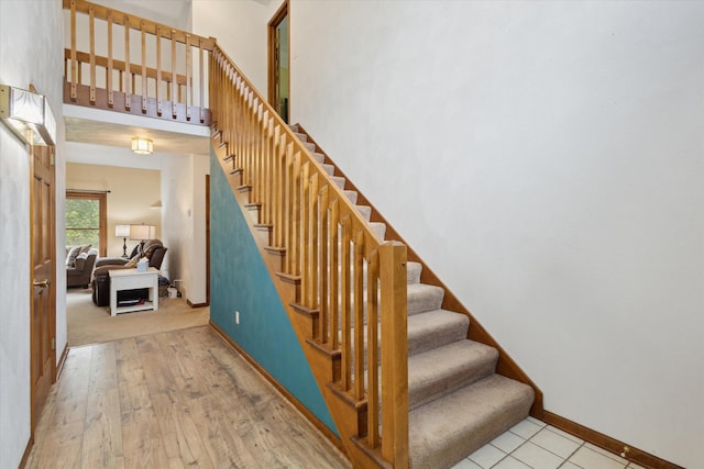 11104 Southbrook Dr, Ceresco, MI 49033 - staircase featuring baseboards, a towering ceiling, and wood finished floors