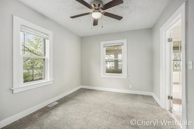 unfurnished room featuring carpet flooring, visible vents, and baseboards