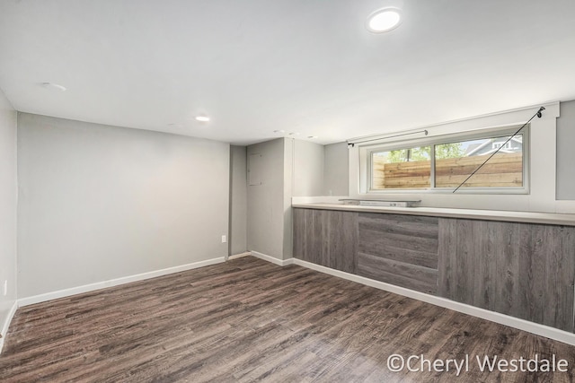 interior space featuring baseboards, dark wood finished floors, and recessed lighting
