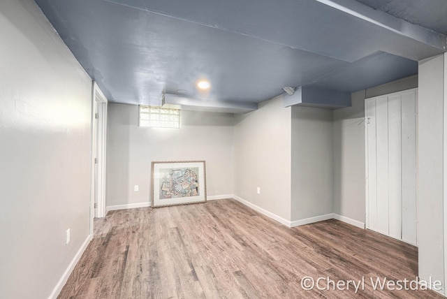 below grade area with baseboards and wood finished floors