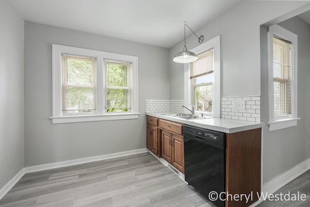 kitchen with a sink, light wood-type flooring, plenty of natural light, and dishwasher