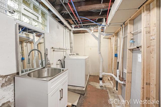 washroom with laundry area, a sink, and washing machine and clothes dryer